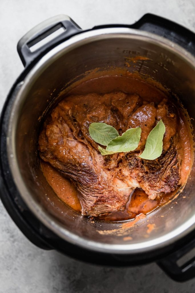 在一個速溶鍋中烤牛肉，然後蓋上醬油和月桂葉。