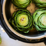 Four fresh artichokes in an Instant Pot ready to cook