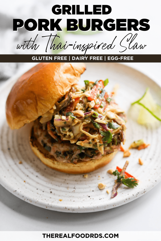A grilled pork burger topped with creamy Thai slaw on a toasted bun