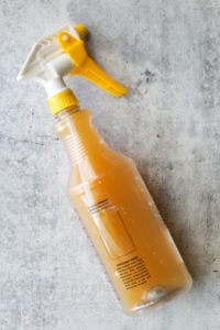 A food-grade plastic spray bottle filled with apple juice